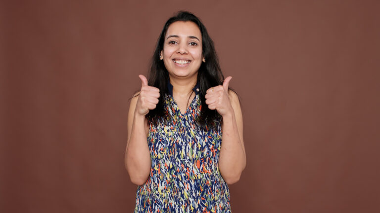 indian model showing okay sign and thumbs up gesture